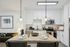 Modern kitchen with sleek white cabinets, stylish pendant lights, and a granite island adorned with elegant tableware.