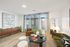 Bright and inviting living room with stylish decor, featuring a comfortable velvet sofa, elegant coffee table, and large windows with ample natural light.
