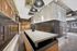 Modern industrial-style mailroom with exposed brick walls, elegant lighting fixtures, and sleek mailbox units, creating a stylish and functional space.