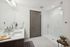 Elegant bathroom featuring a sleek double vanity, spacious glass-enclosed shower, and stylish modern finishes.
