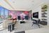 Luxurious modern living room with vibrant abstract wall art, stylish furniture, and expansive city views through large windows.