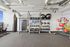 Modern apartment gym featuring top-tier fitness equipment, including a punching bag, stationary bikes, kettlebells, and balance balls, with sleek design for an energetic workout experience.