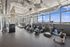 Bright, modern fitness center featuring state-of-the-art exercise equipment and panoramic city views.