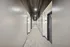 Modern apartment hallway with sleek gray walls, stylish ceiling lighting, and elegant door fixtures.