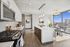 Modern open-concept kitchen with sleek countertops, stainless steel appliances, and floor-to-ceiling windows offering stunning city views.