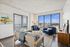 Bright and inviting living room with modern decor, featuring large windows offering stunning cityscape views. Elegant furniture and art add a stylish touch to this urban apartment.