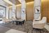 Modern lobby with elegant white armchairs, stylish abstract art, and warm wooden paneling, creating a welcoming atmosphere.