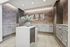Elegant apartment mailroom featuring modern gray mailboxes, chic patterned wallpaper, and a stylish flower arrangement.