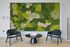 Modern lounge area with a vibrant moss wall art, sleek black chairs, and a minimalist round table, creating a serene and stylish ambiance.
