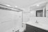 Modern bathroom with elegant glass shower doors, sleek vanity, and bright lighting for a refreshing feel.
