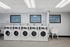 Modern laundry room with five sleek washing machines, bright overhead lighting, and motivational wash, rinse, repeat signage.