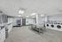 Spacious and modern laundry room featuring multiple washing machines, dryers, and a convenient vending machine.