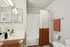 Modern bathroom with elegant fixtures, spacious vanity, and stylish orange accents.