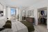 Bright bedroom featuring a luxurious bed, stylish dresser, and spacious open closet with ample natural light from a large window overlooking the city.