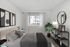 Elegant bedroom with a modern design, showcasing a cozy bed, stylish artwork, and a large window for natural light.