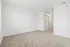 Bright and spacious bedroom featuring fresh white walls, plush carpeting, and a sleek closet with sliding doors.