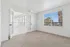 Bright and airy bedroom with large windows, French doors, and plush carpet, offering a serene and inviting atmosphere.
