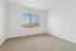 Bright, empty room with plush carpet, large window offering natural light, and neutral tones for endless design possibilities.
