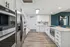Modern kitchen with sleek stainless steel appliances, spacious white cabinetry, and elegant hardwood floors for a stylish living space.