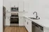 Modern kitchen with stainless steel appliances, sleek white cabinetry, and elegant marble countertops.