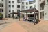 Elegant outdoor courtyard with modern seating and stylish pergola, surrounded by a pristine apartment complex.