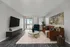Bright and modern living room with a sleek TV, elegant furniture, and a large window offering captivating views.