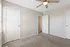 Bright and airy bedroom with beige carpeting, modern ceiling fan, and ample natural light from a sunlit window.