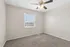Bright, empty room with plush carpet, neutral walls, and a ceiling fan, perfect canvas for personal styling.