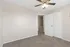 Bright, modern room with soft carpeting, fresh neutral walls, and a ceiling fan, perfect for a cozy bedroom or home office.
