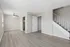 Bright, spacious living area with modern wood flooring, elegant staircase, and sleek ceiling fan, perfect for stylish living.
