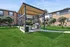 Charming outdoor space with a modern pergola, barbecue grill, and lush green lawn, perfect for gatherings.