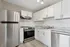 Modern kitchen with stainless steel appliances, sleek white cabinetry, and elegant marble countertops.