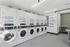Modern laundry facility featuring rows of sleek stacked washers and dryers in a bright, clean space, perfect for convenient on-site laundry care.