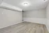 Modern basement room with sleek flooring and fresh paint, offering a blank canvas for customization.