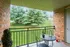 Charming balcony with brick walls overlooking lush green landscape, featuring a cozy outdoor table for perfect relaxation.