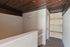 Charming hallway with rustic wooden ceiling and modern shelving, offering a warm and inviting atmosphere.