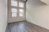 Bright room with high ceilings, large windows, and elegant wood flooring, perfect for a stylish living space.