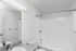 Bright, modern bathroom with sleek white fixtures and a spacious bathtub, perfect for relaxation.