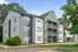 Charming apartment complex with modern grey siding, inviting balconies, and lush greenery.