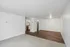 Modern living space featuring sleek hardwood floors, cozy carpeted area, and inviting open-concept kitchen with stainless steel appliances.