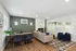 Contemporary living room with stylish décor, featuring a cozy fireplace, sleek desk area, and chic furniture, creating a warm and inviting ambiance.