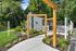 Charming residential entrance with lush greenery, modern wooden frames, and a cozy porch, offering a welcoming and stylish vibe.