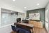 Modern office space with stylish decor featuring a sleek desk, two plush chairs, and large abstract artwork on a green accent wall.