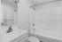 Sleek modern bathroom featuring a pristine white bathtub and stylish vanity with a large mirror.