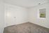 Bright room with plush carpeting, a clean white door, and a sunlit window for a cozy, inviting ambiance.