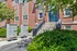 Charming apartment entrance with lush greenery and convenient mailbox access, perfect for urban living.