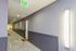 Modern apartment hallway with sleek lighting and plush carpet, featuring well-maintained doors and bright exit sign.