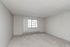 Spacious, well-lit room with large window and plush carpet, perfect for creating a cozy retreat.