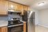 Modern kitchen featuring stainless steel appliances, sleek countertops, and warm wooden cabinetry.