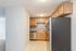 Modern kitchen with stainless steel appliances and warm wooden cabinetry, featuring sleek tile flooring for easy maintenance.